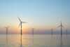 Havvindmøller til havs i solnedgang – symbol på fornybar energiproduksjon