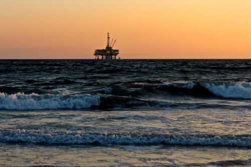 Oljerigg i havet i solnedgang